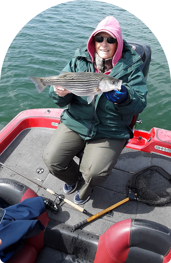Smiling angler with a striped bass